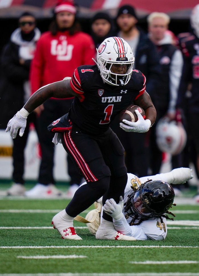 (Bethany Baker  |  The Salt Lake Tribune) Utah Utes running back Jaylon Glover (1) runs the ball and avoids a tackle by Colorado Buffaloes defensive end Taijh Alston (49) at Rice-Eccles Stadium in Salt Lake City on Saturday, Nov. 25, 2023.