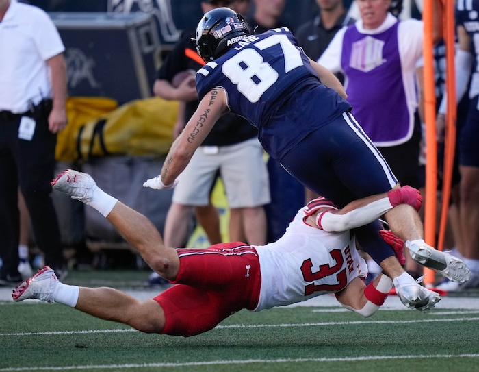 (Francisco Kjolseth  | The Salt Lake Tribune) Utah State Aggies tight end Broc Lane (87) is tackled by Utah Utes linebacker Trey Reynolds (37) as Utah State hosts the University of Utah during the second half of an NCAA college football game Saturday, Sept. 14, 2024, in Logan, Utah.