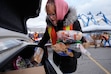 (Francisco Kjolseth  | The Salt Lake Tribune) Volunteer Charlie Felgar loads bread into the trunk of a car for the Utah Food for Families distribution at Calvary Salt Lake in Murray on Thursday, March 6, 2025. It's a "frightening" time for food banks across the state, where pandemic demand never died down and now inflation, the threat of tariffs and impending federal layoffs have exacerbated the situation.