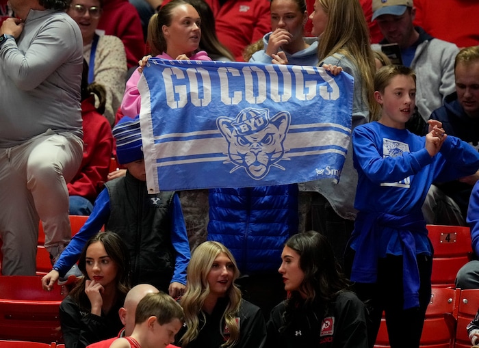 (Bethany Baker  |  The Salt Lake Tribune) A Brigham Young Cougars fan holds up a flag during the game against the Utah Utes at the Jon M. Huntsman Center in Salt Lake City on Saturday, Dec. 9, 2023.