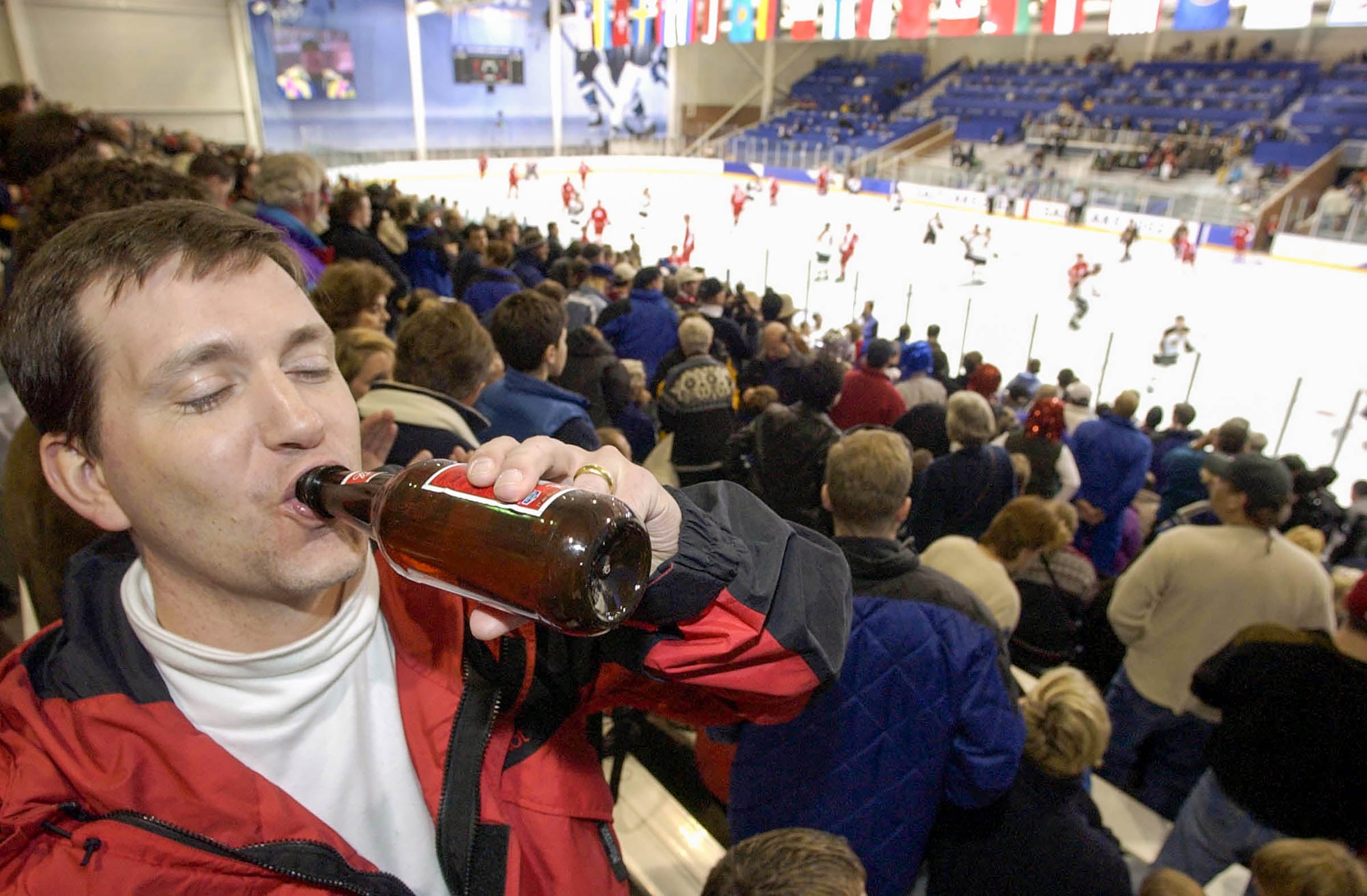 (Ryan Galbraith | The Salt Lake Tribune) Pete Wilson from Summit, N.J., takes a swig from his beer Sunday, Feb. 10, 2002, at Peaks Ice Arena in Provo as Austria and Germany compete in men’s hockey in the 2002 Winter Olympics. Today was the first time beer was for sale on a Sunday in Provo. “It's not a real beer though,” said Wilson, referring to Utah's 3.2% alcohol content.