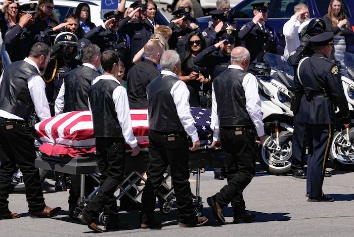 (Francisco Kjolseth  |  The Salt Lake Tribune) Pallbearers carry the casket containing Santaquin police Sgt. Bill Hooser following services at the UCCU Center at Utah Valley University on Monday, May 13, 2024.