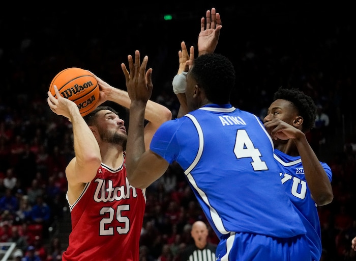 (Bethany Baker  |  The Salt Lake Tribune) Utah Utes guard Rollie Worster (25) shoots as Brigham Young Cougars forward Atiki Ally Atiki (4) and Brigham Young Cougars guard Jaxson Robinson (2) block at the Jon M. Huntsman Center in Salt Lake City on Saturday, Dec. 9, 2023.