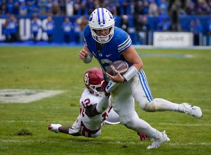 (Bethany Baker  |  The Salt Lake Tribune) Oklahoma Sooners defensive back Key Lawrence (12) tries to tackle Brigham Young Cougars quarterback Jake Retzlaff (12) before he scores a touchdown at LaVell Edwards Stadium in Provo on Saturday, Nov. 18, 2023.