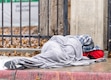 (Rick Egan | The Salt Lake Tribune) An unsheltered person wraps in a blanket to stay warm on Rio Grande Street in January 2024. Frigid temperatures have triggered a Code Blue, opening up more space in shelters.