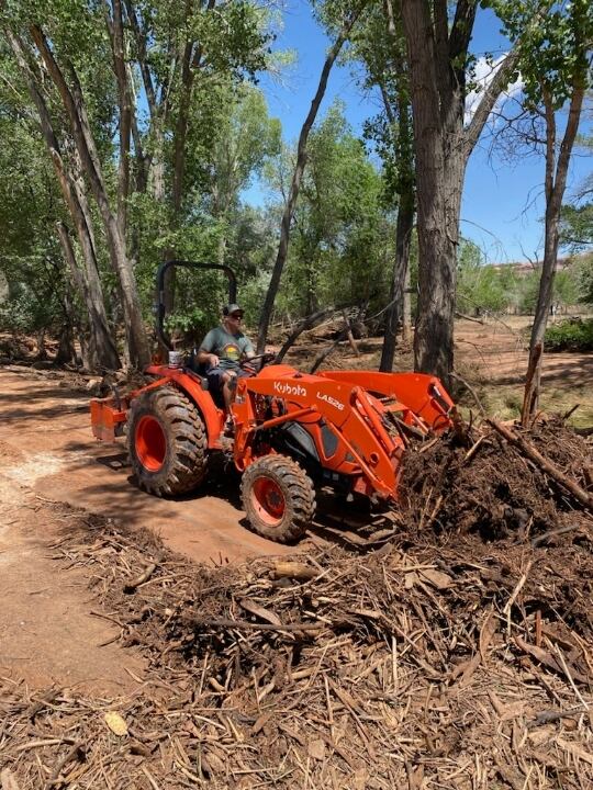 (Doug McMurdo for The Salt Lake Tribune) Moab City Council member Jason Taylor uses a tractor to remove flood debris.