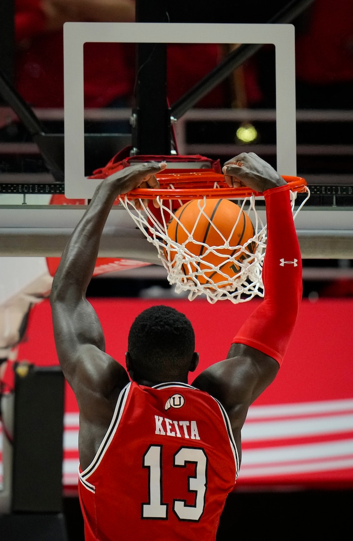 (Bethany Baker  |  The Salt Lake Tribune) Utah Utes center Keba Keita (13) dunks the ball during the game against the Brigham Young Cougars at the Jon M. Huntsman Center in Salt Lake City on Saturday, Dec. 9, 2023.