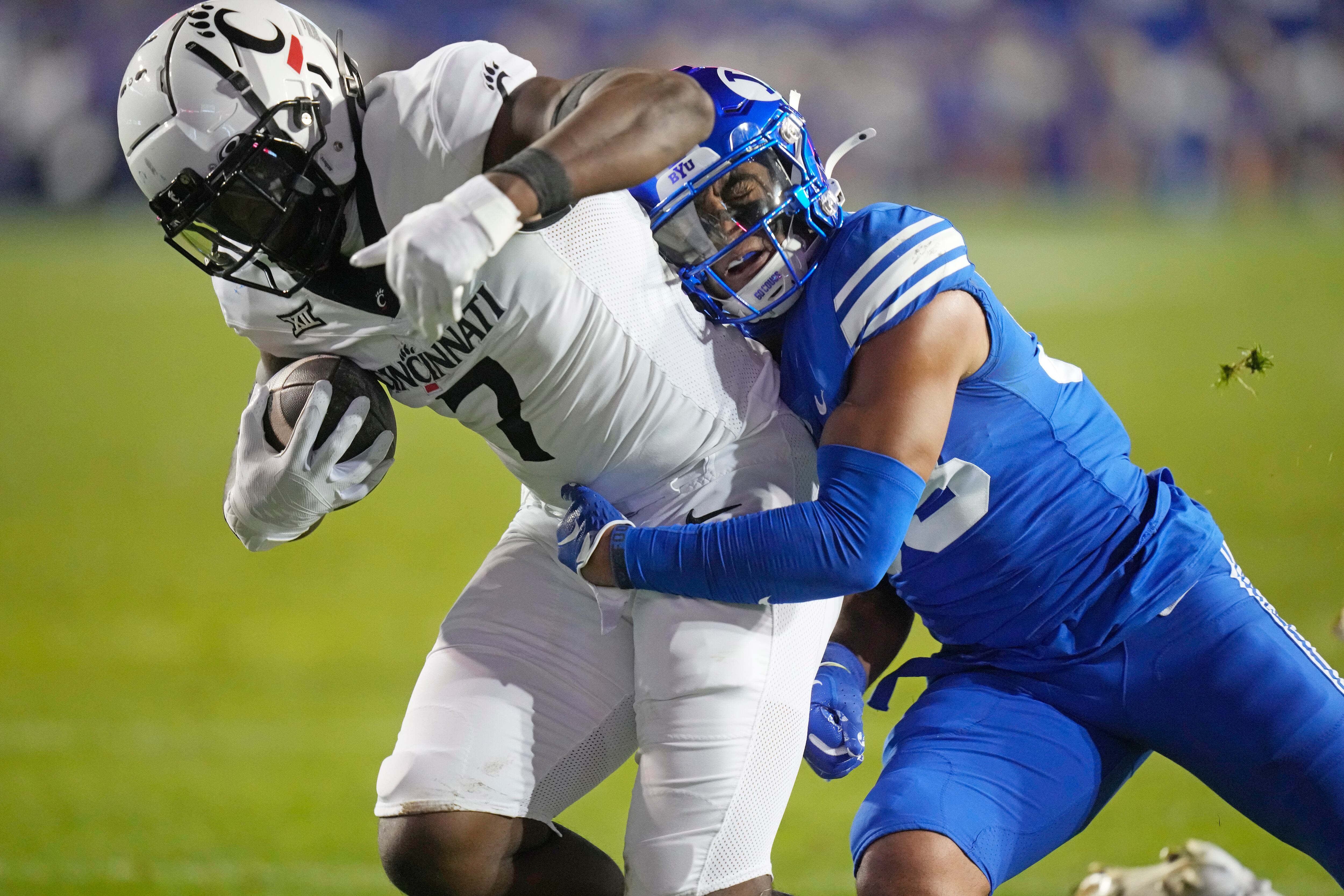 Cincinnati tight end Chamon Metayer (7) scores as he is tackled by BYU safety Raider Damuni during the first half of an NCAA college football game Friday, Sept. 29, 2023, in Provo, Utah. (AP Photo/Rick Bowmer)