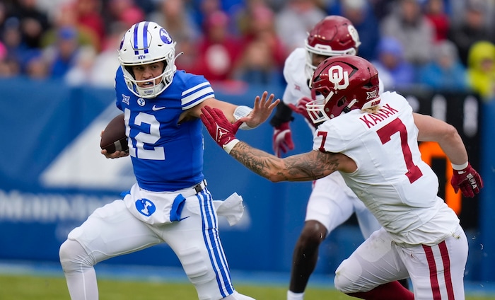 (Bethany Baker | The Salt Lake Tribune) Brigham Young Cougars quarterback Jake Retzlaff (12) blocks Oklahoma Sooners linebacker Jaren Kanak (7) at LaVell Edwards Stadium in Provo on Saturday, Nov. 18, 2023.