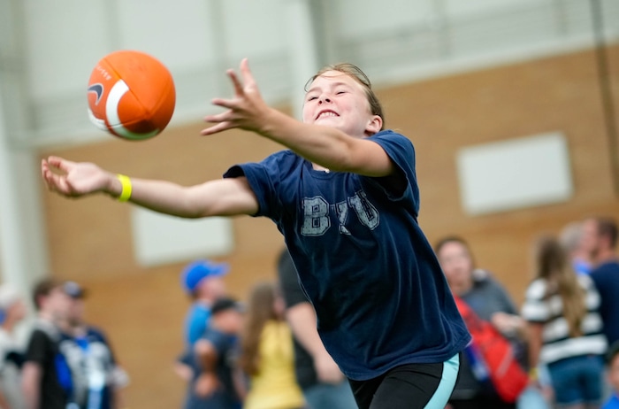 (Francisco Kjolseth | The Salt Lake Tribune) Kaylie Anderson, 11, stretches out for a pass as BYU celebrates their entrance into the Big 12 Conference with a big party featuring numerous activities on Saturday, July 1, 2023.