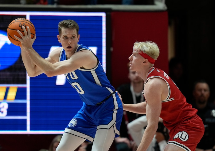 (Bethany Baker  |  The Salt Lake Tribune) Brigham Young Cougars guard Spencer Johnson (20) catches a pass as Utah Utes guard Hunter Erickson (0) defends at the Jon M. Huntsman Center in Salt Lake City on Saturday, Dec. 9, 2023.