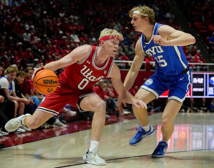 (Bethany Baker  |  The Salt Lake Tribune) Utah Utes guard Hunter Erickson (0) dribbles around Brigham Young Cougars guard Richie Saunders (15) at the Jon M. Huntsman Center in Salt Lake City on Saturday, Dec. 9, 2023.