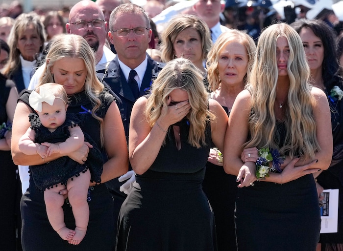 (Francisco Kjolseth  |  The Salt Lake Tribune) Kinda Hooser, center, alongside her daughters Courtney and Shaylee, follows the casket containing her husband Santaquin police Sgt. Bill Hooser following ceremonies at the UCCU Center at Utah Valley University on Monday, May 13, 2024.