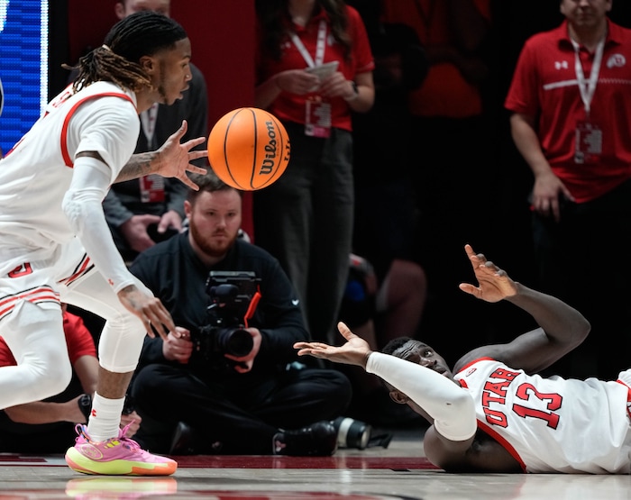 (Francisco Kjolseth  |  The Salt Lake Tribune) Utah Utes center Keba Keita (13) hands off to Utah Utes guard Deivon Smith (5) in PAC-12 basketball action between the Utah Utes and the Arizona Wildcats at the Jon M. Huntsman Center, on Thursday, Feb. 8, 2024.