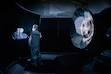 (Allison Bills | Space Dynamics Laboratory) A Space Dynamics Laboratory engineer standing next to the Atmospheric Waves Experiment (AWE) telescopes, with baffle, in a stray light test facility.