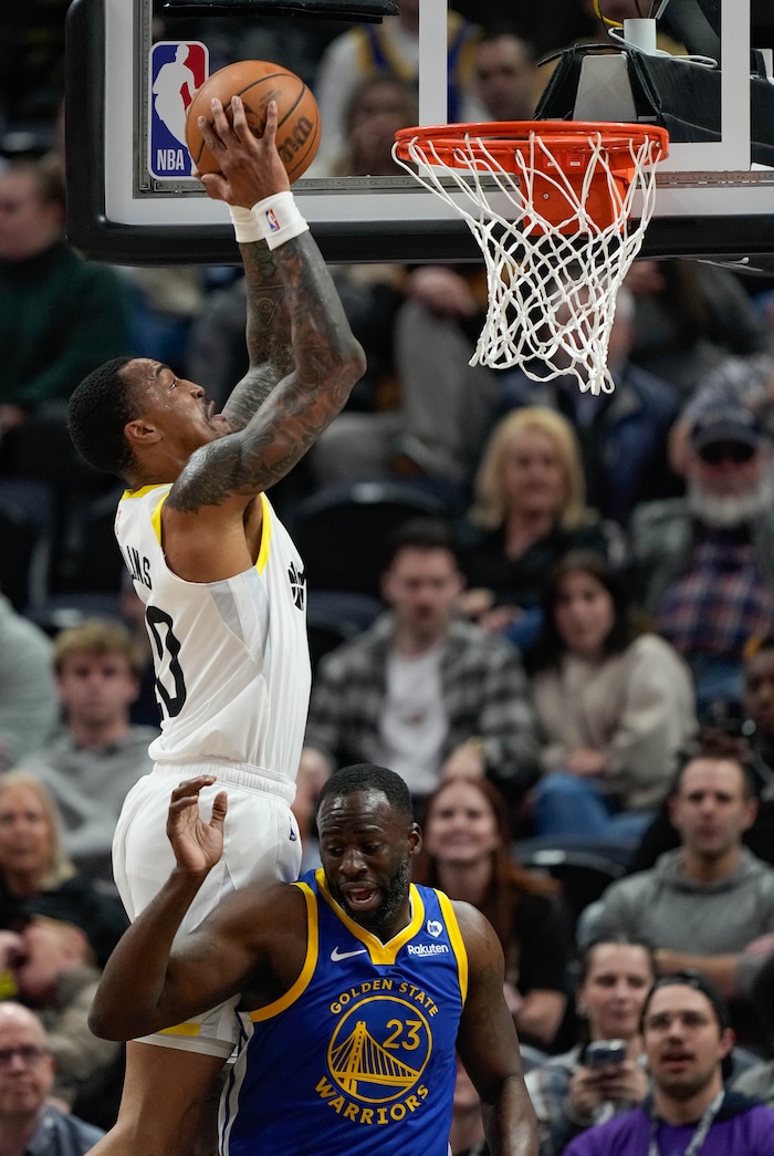 (Francisco Kjolseth  |  The Salt Lake Tribune) Utah Jazz forward John Collins (20) dunks over Golden State Warriors forward Draymond Green (23) during an NBA basketball game Thursday, Feb. 15, 2024, in Salt Lake City.