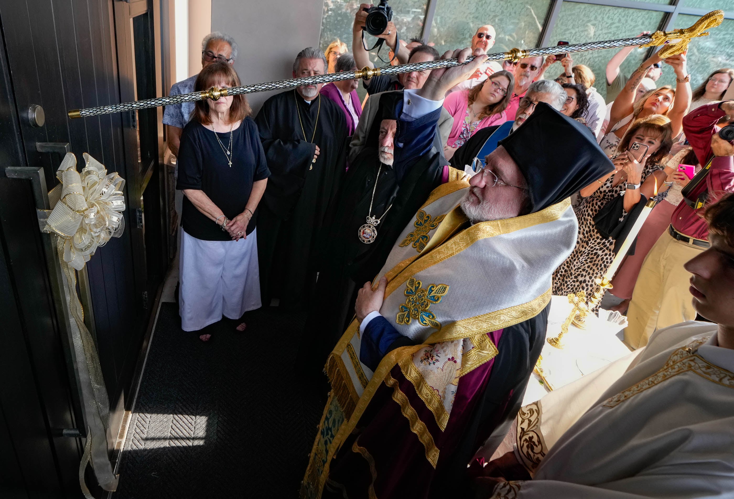 (Francisco Kjolseth | The Salt Lake Tribune) Archbishop Elpidophoros of America uses his staff to kock for the opening of the doors for the newly transformed St. Anna Greek Orthodox Church in Sandy on Saturday, July 13, 2024. The new church was transformed from a garden center into a sacred sanctuary.