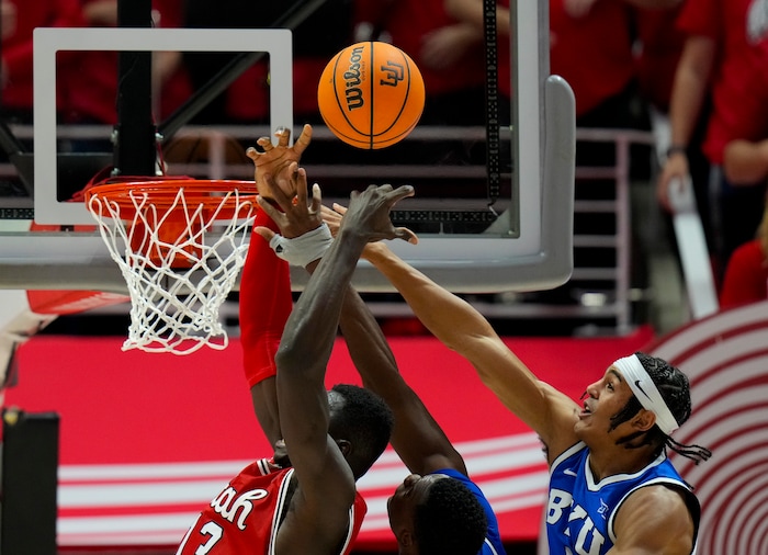 (Bethany Baker  |  The Salt Lake Tribune) Utah Utes center Keba Keita (13) tries to block a shot from Brigham Young Cougars forward Atiki Ally Atiki (4) as guard Trey Stewart (1) assists at the Jon M. Huntsman Center in Salt Lake City on Saturday, Dec. 9, 2023.