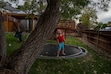 (Trent Nelson  |  The Salt Lake Tribune) Harper Tribe on the family's backyard trampoline in South Jordan on Monday, Sept. 16, 2024. At left is Miriam Tribe. Harper has been waiting on a list for nine years to get support from Utah’s Division of Services for People with Disabilities.