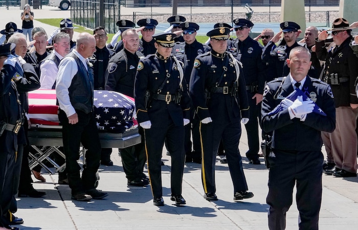 (Francisco Kjolseth  |  The Salt Lake Tribune) Santaquin police Lt. Mike Wall, right, walks ahead of pallbearers carrying the casket containing Santaquin police Sgt. Bill Hooser following services at the UCCU Center at Utah Valley University on Monday, May 13, 2024.