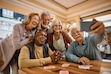 (Getty Images, sponsored) Multiracial group of happy senior people taking selfie with cell phone in nursing home.