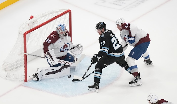 (Bethany Baker  |  The Salt Lake Tribune) Colorado Avalanche goaltender Justus Annunen (60) blocks a shot as Utah Hockey Club center Barrett Hayton (27) tries to score while Colorado Avalanche defenseman Josh Manson (42) defends during the game between the Utah Hockey Club and the Colorado Avalanche at the Delta Center in Salt Lake City on Thursday, Oct. 24, 2024.