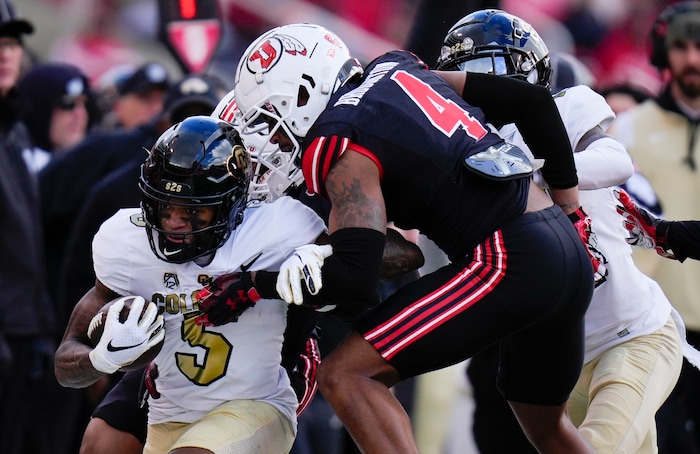 (Bethany Baker  |  The Salt Lake Tribune) Colorado Buffaloes wide receiver Jimmy Horn Jr. (5) is tackled by Utah Utes cornerback JaTravis Broughton (4) and Utah Utes cornerback Smith Snowden (17) at Rice-Eccles Stadium in Salt Lake City on Saturday, Nov. 25, 2023.