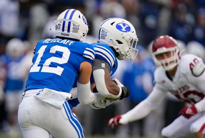 (Bethany Baker  |  The Salt Lake Tribune) Brigham Young Cougars quarterback Jake Retzlaff (12) hands the ball off to Brigham Young Cougars running back Aidan Robbins (3) against the Oklahoma Sooners at LaVell Edwards Stadium in Provo on Saturday, Nov. 18, 2023.