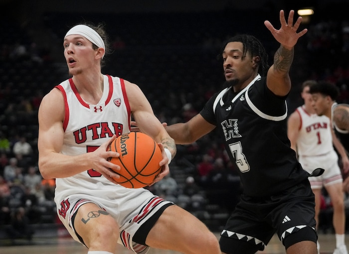 (Bethany Baker  |  The Salt Lake Tribune) Utah Utes guard Gabe Madsen (55) looks to pass the ball as Hawaii Warriors guard JoVon McClanahan (3) defends at the Delta Center in Salt Lake City on Thursday, Nov. 30, 2023.
