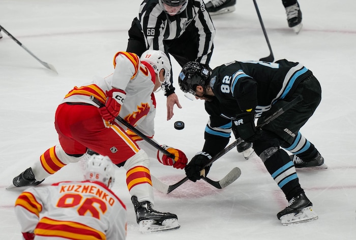 (Francisco Kjolseth  | The Salt Lake Tribune) Calgary Flames center Yegor Sharangovich (17) and Utah Hockey Club center Kevin Stenlund (82) face off during an NHL hockey game at the Delta Center in Salt Lake City on Wednesday, Oct. 30, 2024.