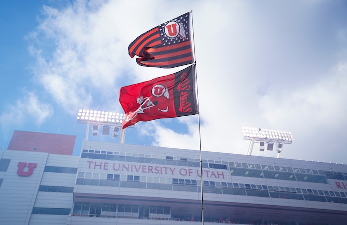 (Bethany Baker  |  The Salt Lake Tribune) Fans wave flags ahead of the game against the Colorado Buffaloes at Rice-Eccles Stadium in Salt Lake City on Saturday, Nov. 25, 2023.