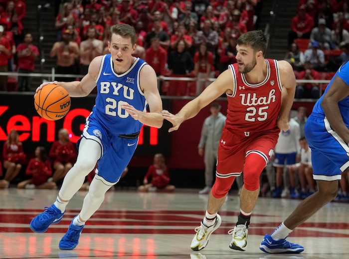 (Bethany Baker  |  The Salt Lake Tribune) Brigham Young Cougars guard Spencer Johnson (20) drives to the basket as Utah Utes guard Rollie Worster (25) defends at the Jon M. Huntsman Center in Salt Lake City on Saturday, Dec. 9, 2023.