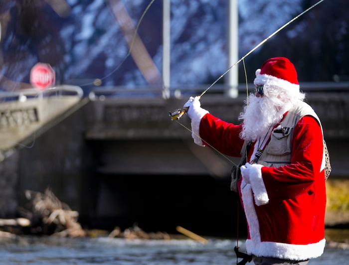 (Bethany Baker  |  The Salt Lake Tribune) Rudy Schenk, a fly fisherman dressed as Santa Claus, casts his line in the Provo River at Vivian Park in Provo Canyon on Saturday, Dec. 23, 2023.