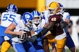 Brigham Young quarterback Jake Retzlaff, left, tries to spin away from Arizona State defensive lineman Prince Dorbah (32) during the first half of an NCAA college football game Saturday, Nov. 23, 2024, in Tempe, Ariz. (AP Photo/Ross D. Franklin)