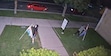 Two masked individuals vandalizing and stealing pride flags outside Logan Pride House at night.