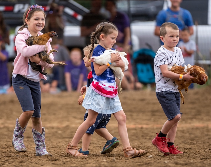 (Rick Egan | The Salt Lake Tribune) The winning chicken catchers proudly  carrie their birds out of the arena, during the Liberty Days Celebration in Liberty, Utah, on Tuesday, July 4, 2023.  Kids that catch the chickens get to keep them. 