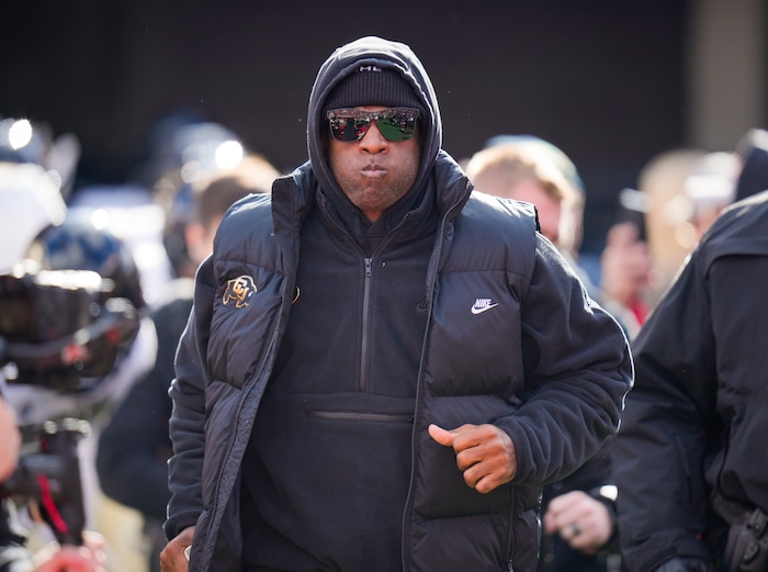 (Bethany Baker  |  The Salt Lake Tribune) Colorado Buffaloes head coach Deion Sanders runs onto the field ahead of the game against the Utah Utes at Rice-Eccles Stadium in Salt Lake City on Saturday, Nov. 25, 2023.