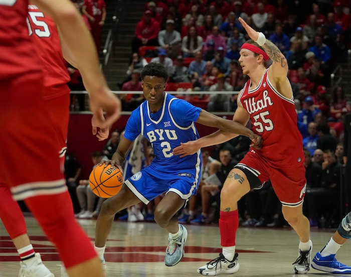 (Bethany Baker  |  The Salt Lake Tribune) Brigham Young Cougars guard Jaxson Robinson (2) drives to the basket as Utah Utes guard Gabe Madsen (55) defends at the Jon M. Huntsman Center in Salt Lake City on Saturday, Dec. 9, 2023.