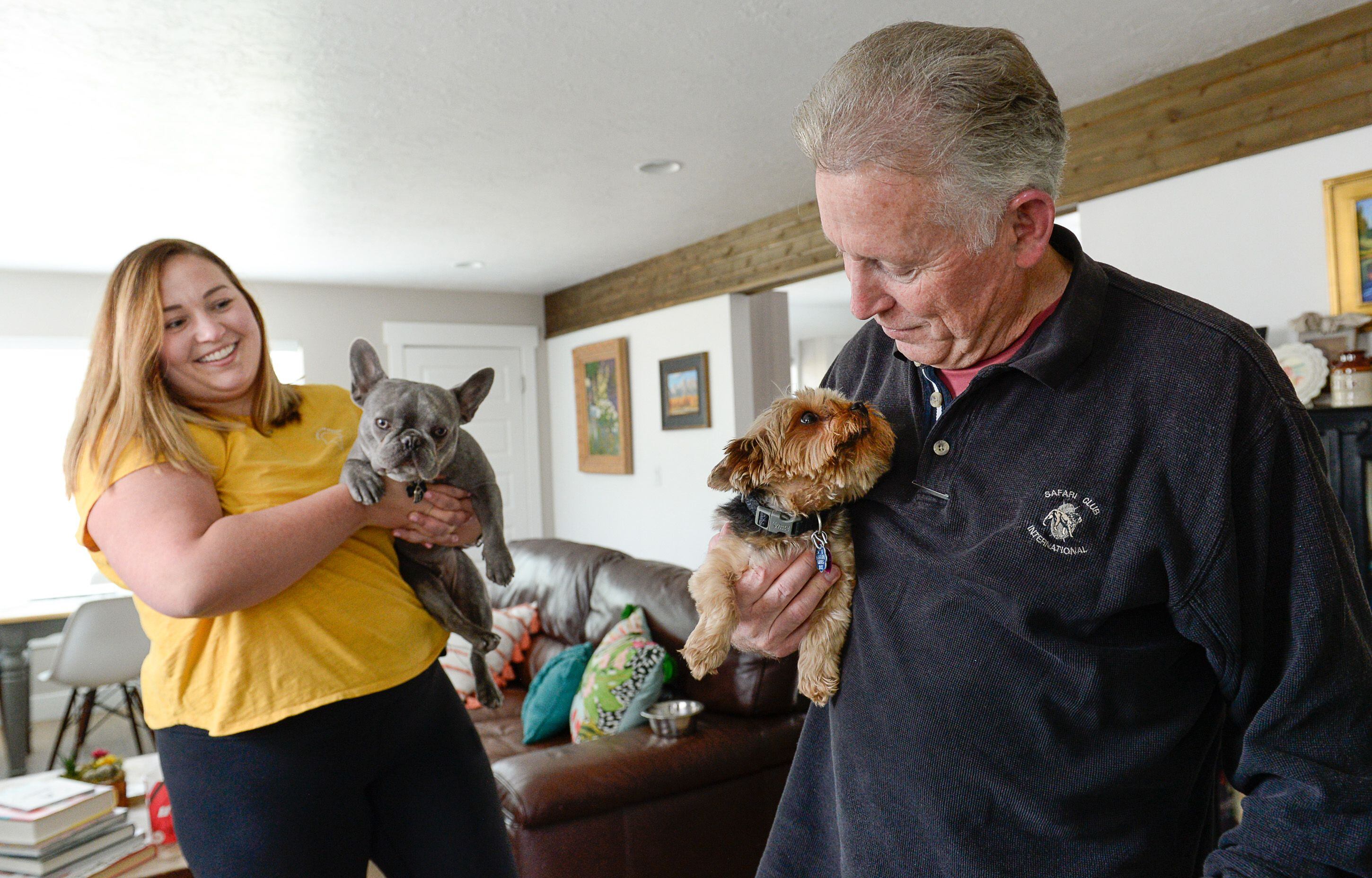 (Francisco Kjolseth | The Salt Lake Tribune) Courtney Hatch holds Rothko as her father Floyd gets a little love from her other dog Lucy during a recent visit at her home in Sugarhouse on Wed. June 12, 2019. Intermountain Healthcare is beginning a global collaboration and study to discover new links between genetics and human disease that will involve the collection of half-a-million DNA samples. This initiative focuses on people with the PKP2 gene, a mutation that can lead to heart failure. Both Courtney and her father have the genetic condition, and are participating in the study.