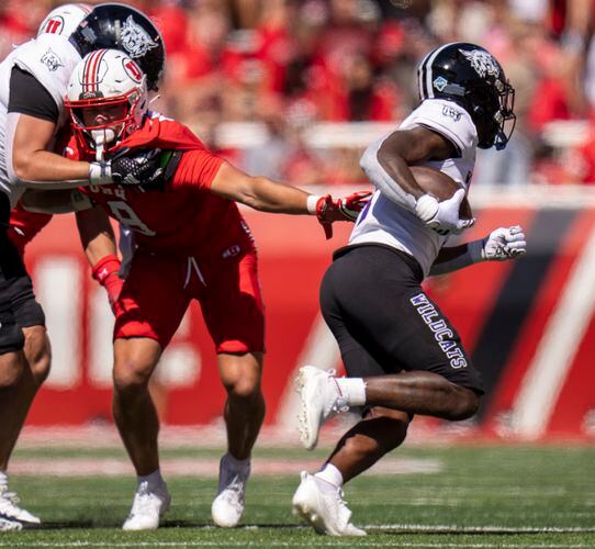 (Rick Egan | The Salt Lake Tribune) Utah Utes safety Cole Bishop (8) is held back as he reaches for Weber State Wildcats running back Damon Bankston (1), in football action between the Utah Utes and the Weber State Wildcats, at Rice-Eccles Stadium, on Saturday, Sept. 16, 2023.